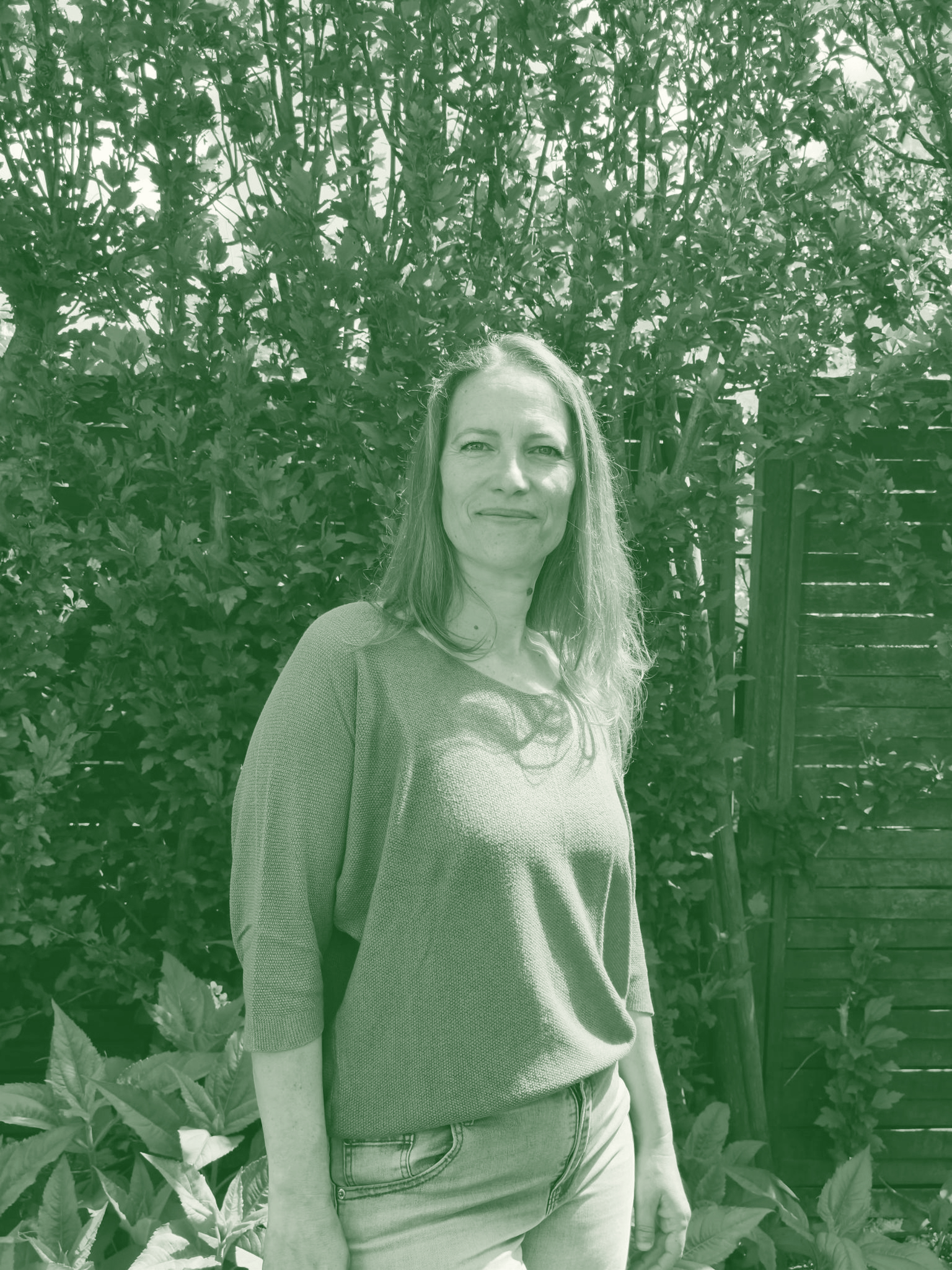 Portrait de Nathalie Blanc, correctrice professionnelle et rédactrice web SEO devant un fond d’arbustes